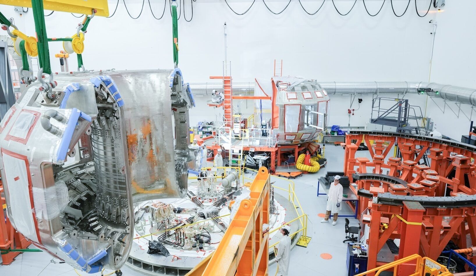Inside of a fusion reactor facility with white walls and multicolored equipment