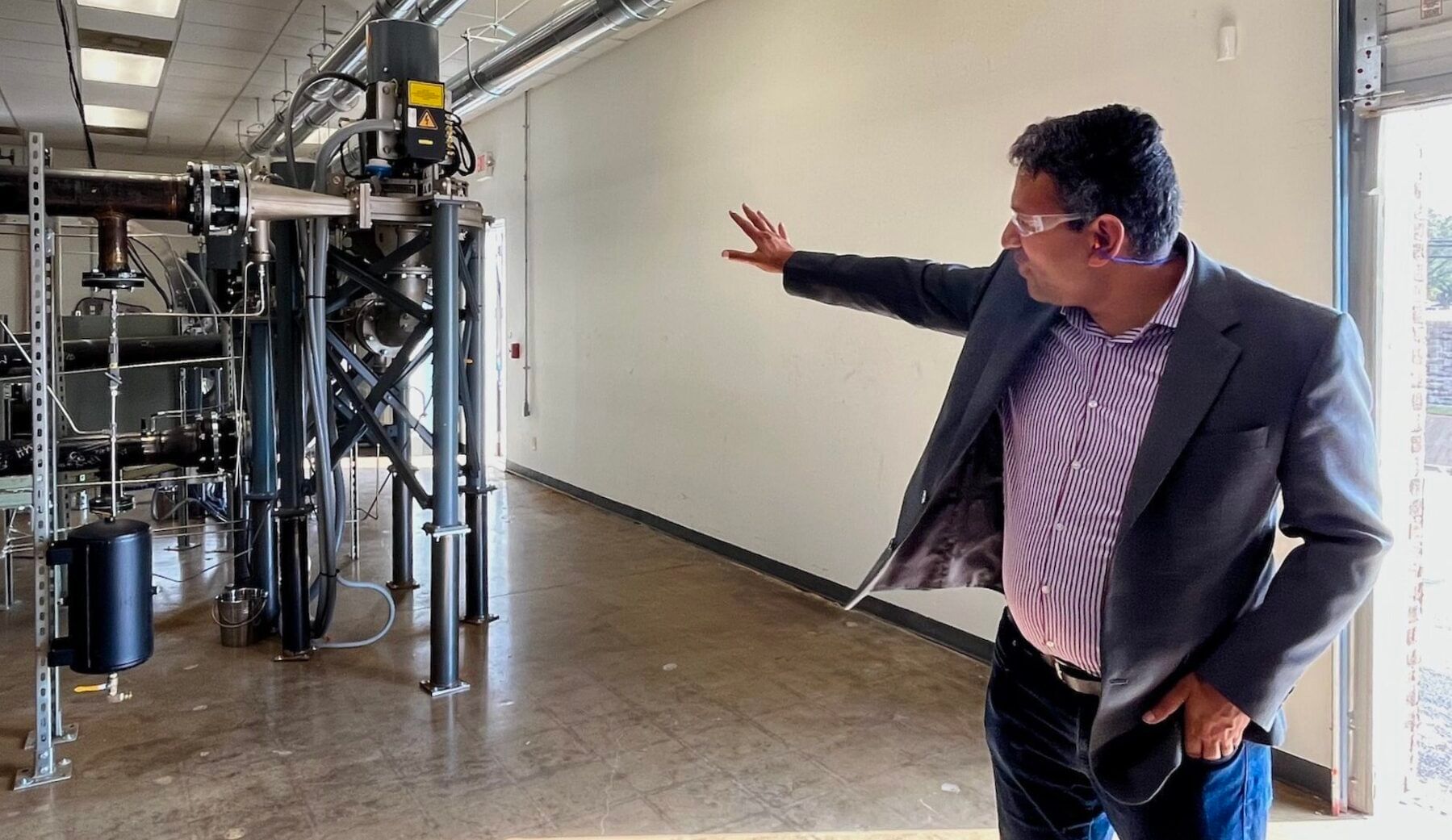 A person points at a network of piping in a building