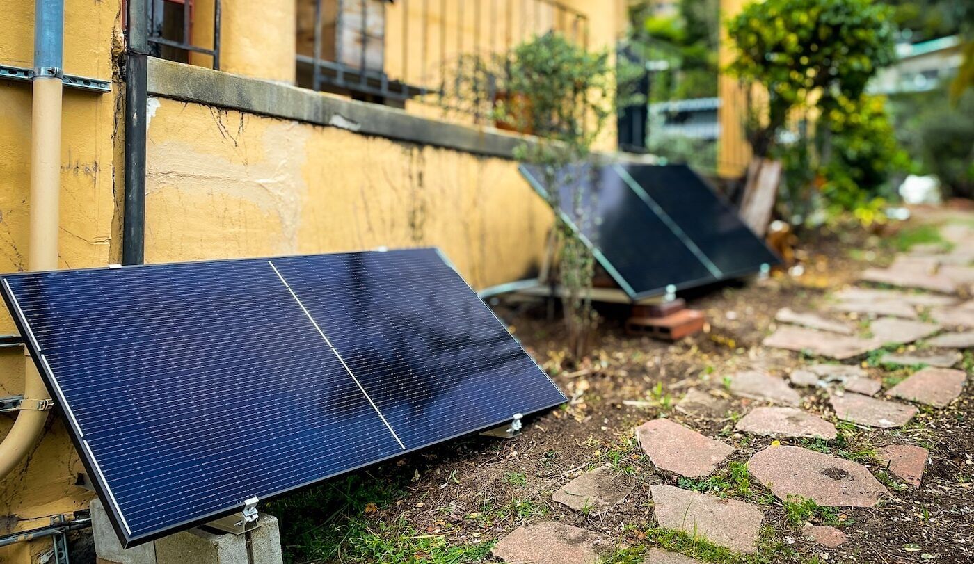 Solar panels lean against a building