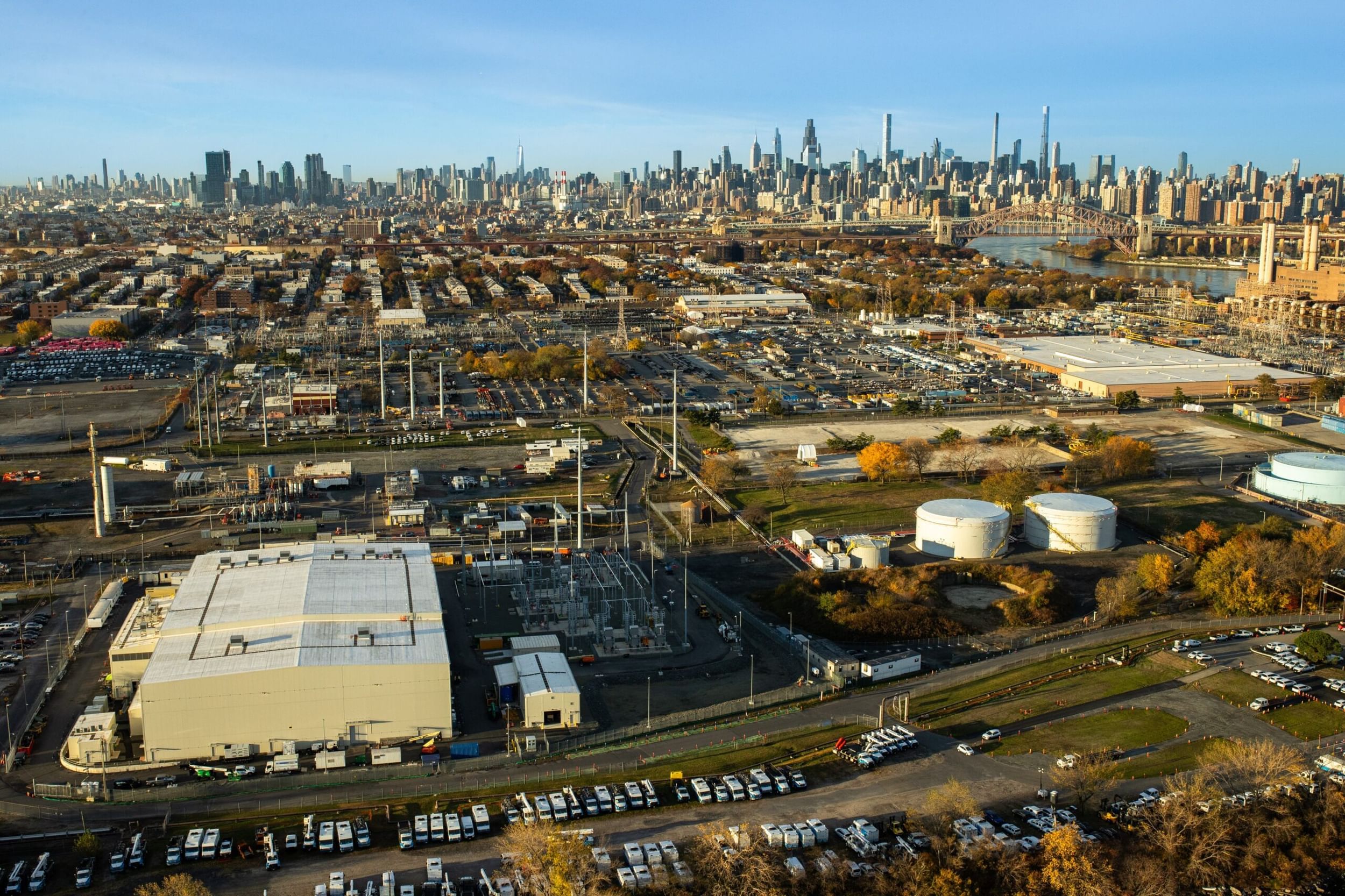 New York City skyline in the distance on a clear day with a light colored converter station on the left