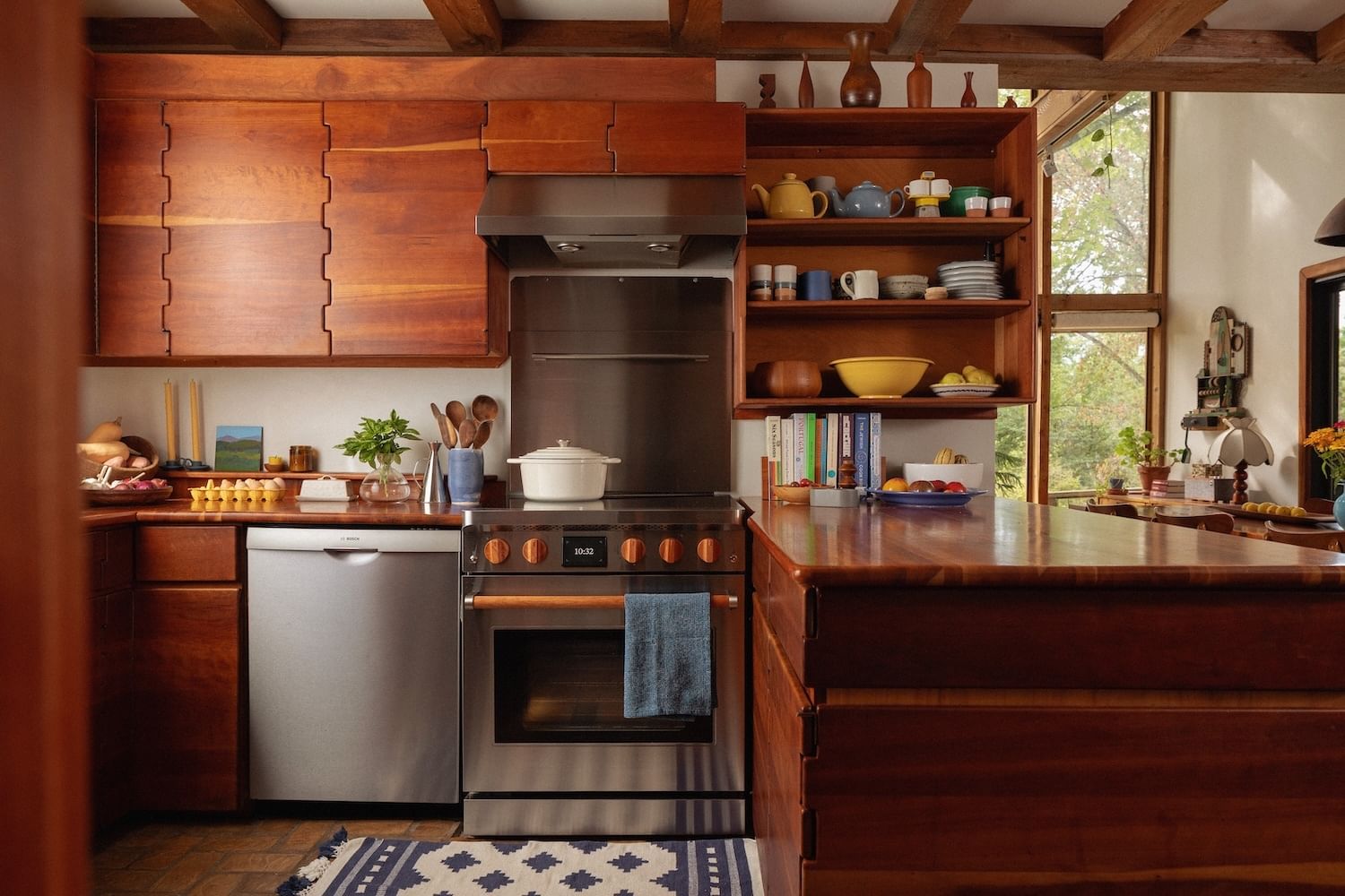 Electric stove in a home kitchen with interesting wood cabinets, open shelving with dishes