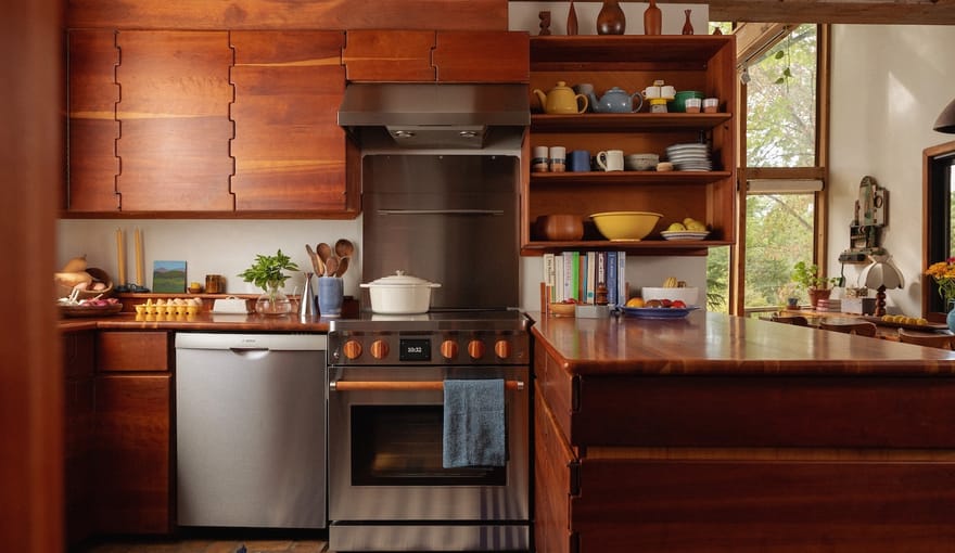 Electric stove in a home kitchen with interesting wood cabinets, open shelving with dishes