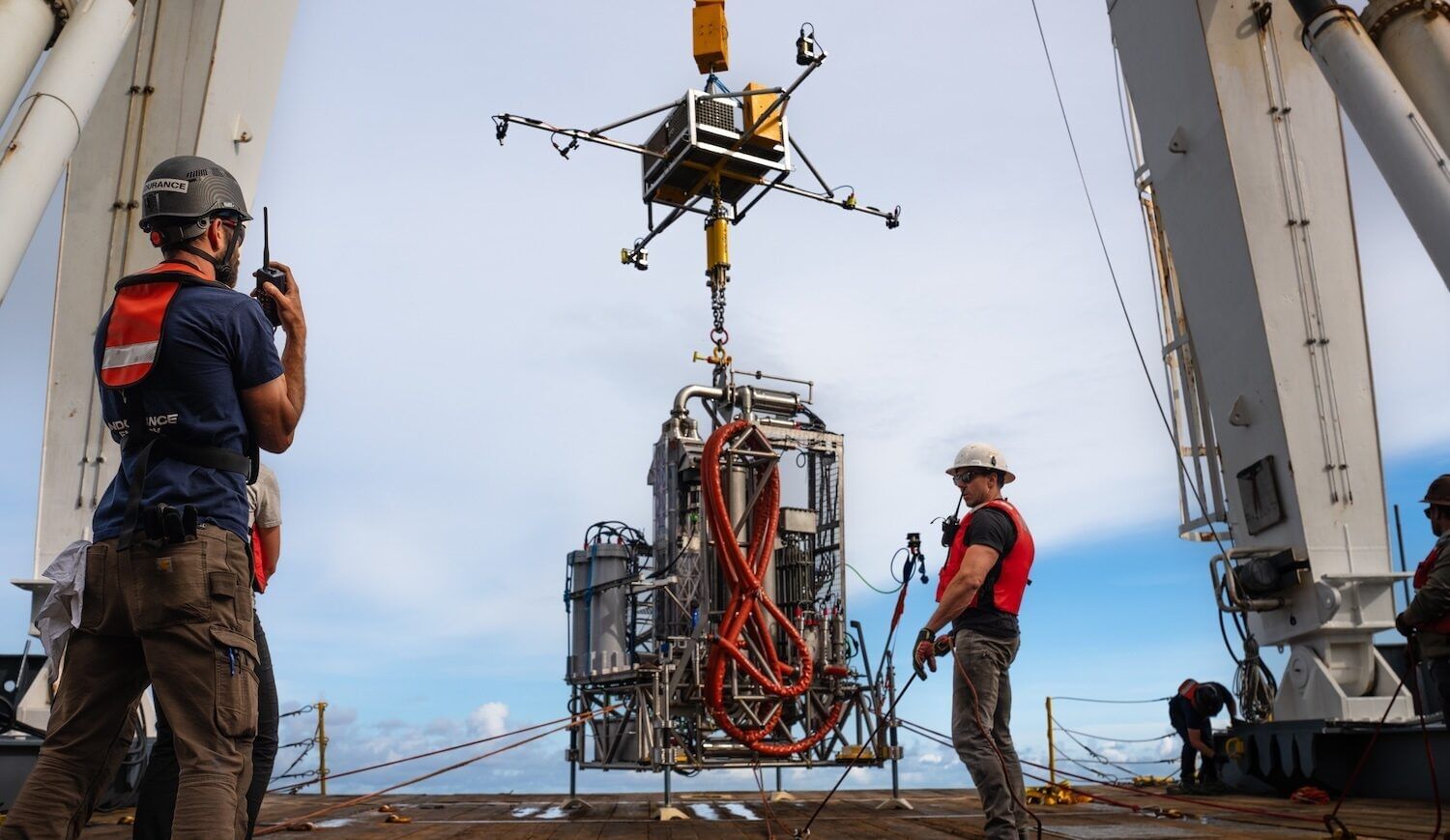 A complicated-looking drill is lowered onto a deck.