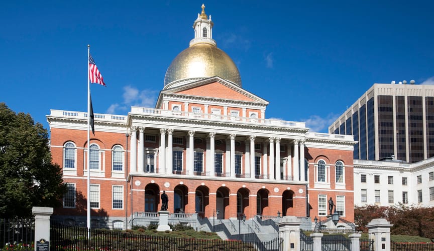 Redbrick statehouse of three stories with a gleaming golden dome