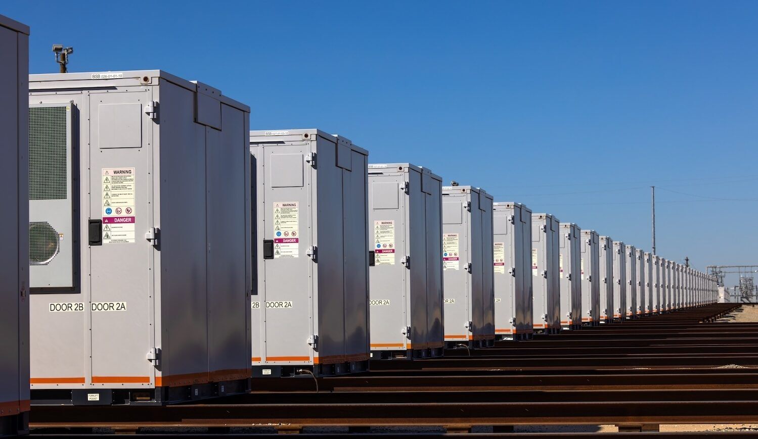 Gray metal boxes lined up with a blue sky overhead