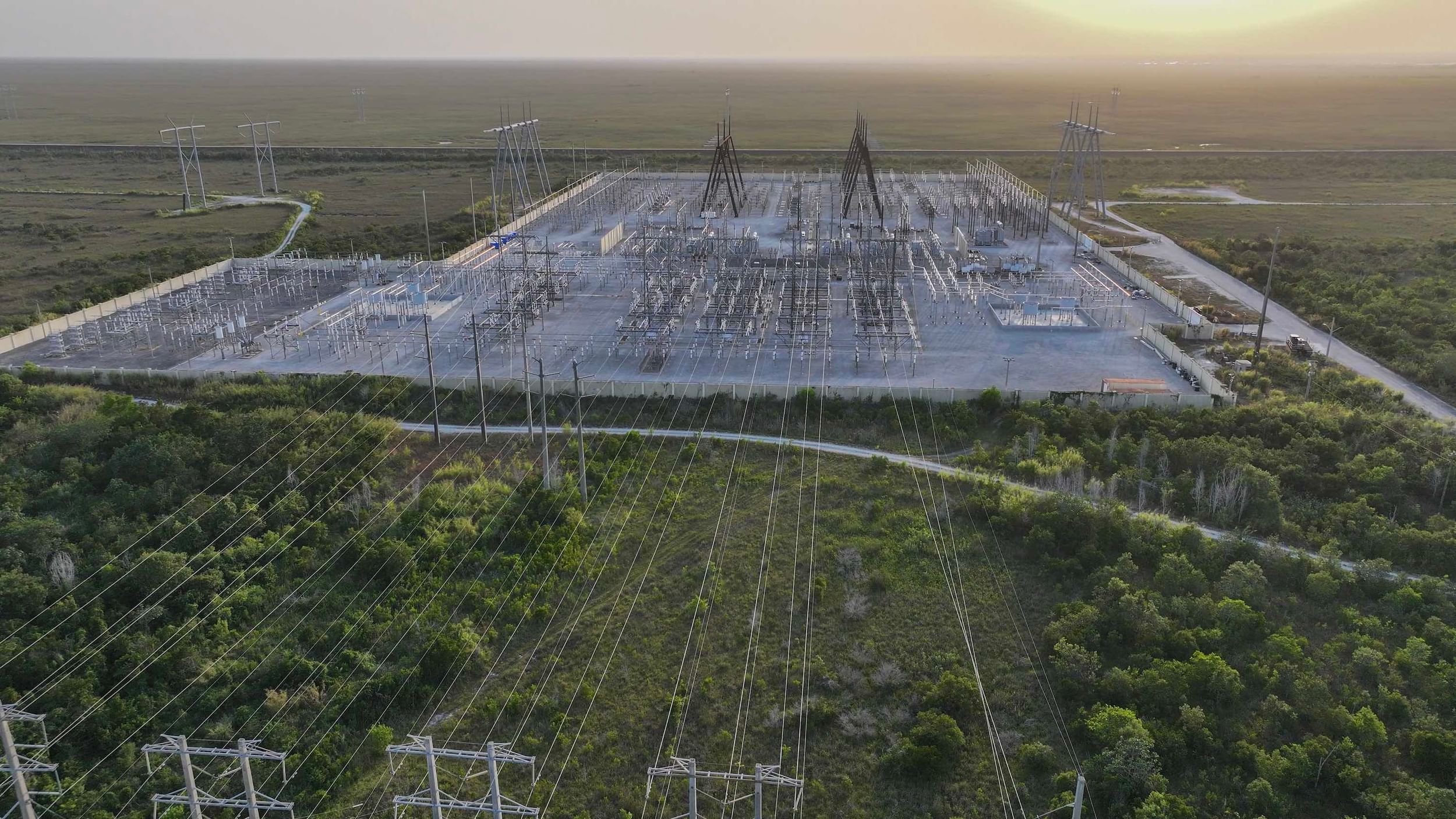 In an aerial view, high voltage power lines run along the electrical power grid