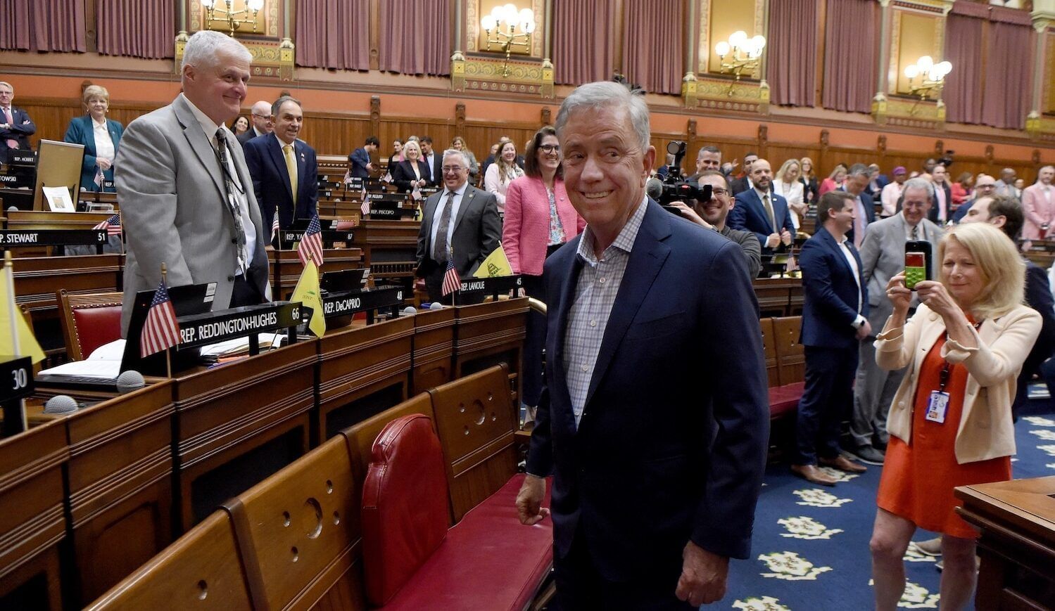 A man in a suit in a crowded government building.