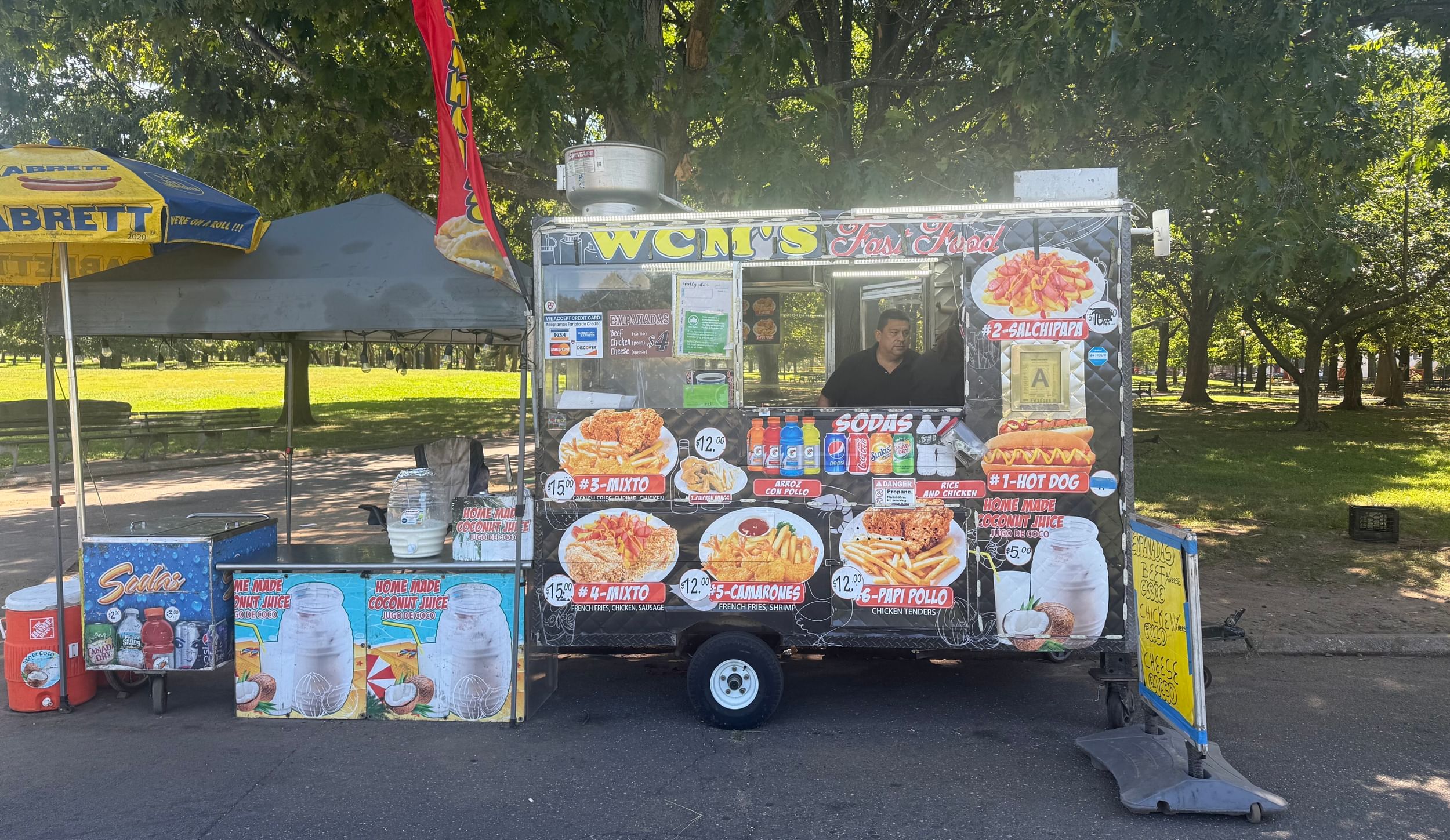 A man inside a food cart in a park