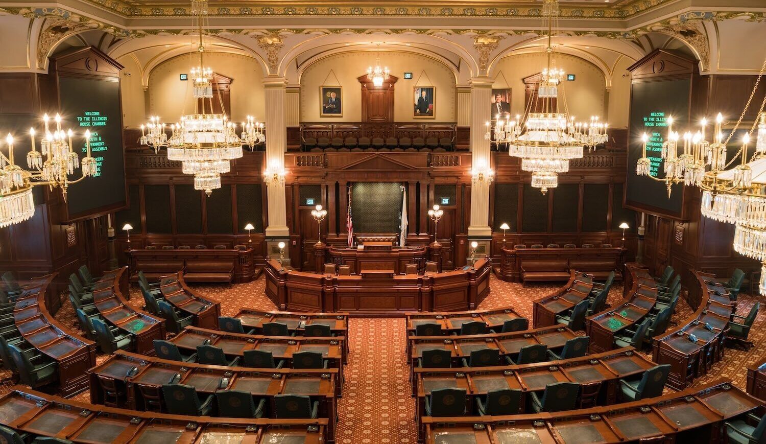 Large room with rows of seats and chandeliers