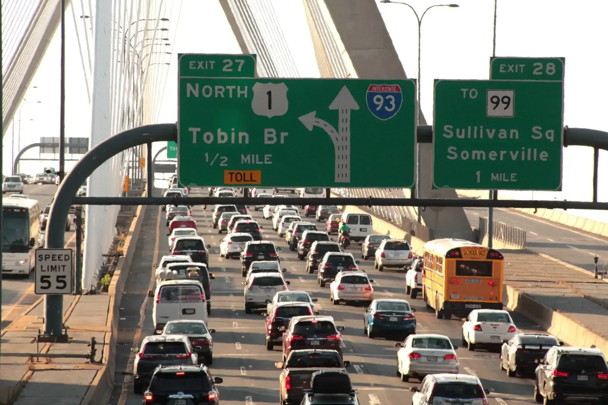 Shot of the multilane Tobin Bridge on Interstate 93 from above with signs for exits 27 and 28