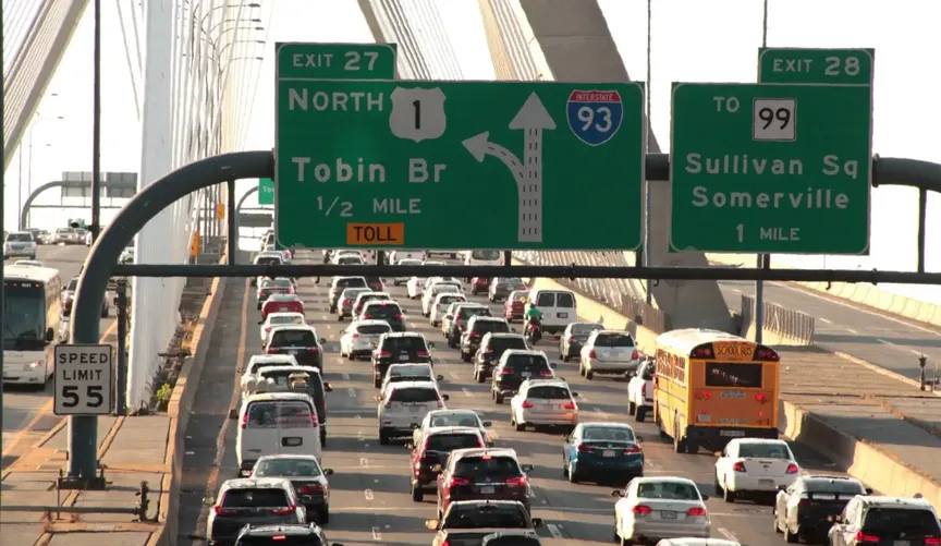 Shot of the multilane Tobin Bridge on Interstate 93 from above with signs for exits 27 and 28