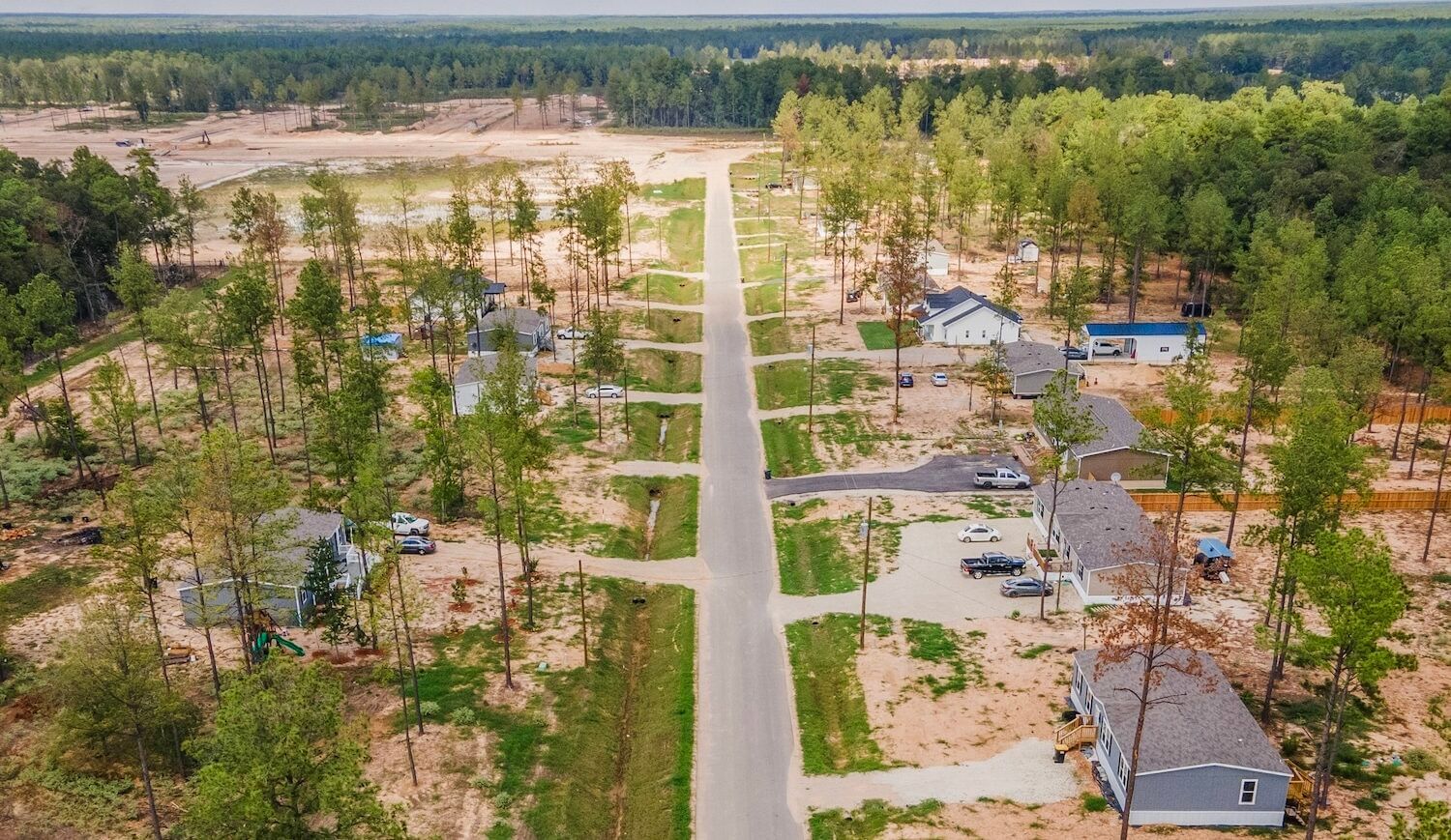 Homes on grassy sites with trees, shot from above