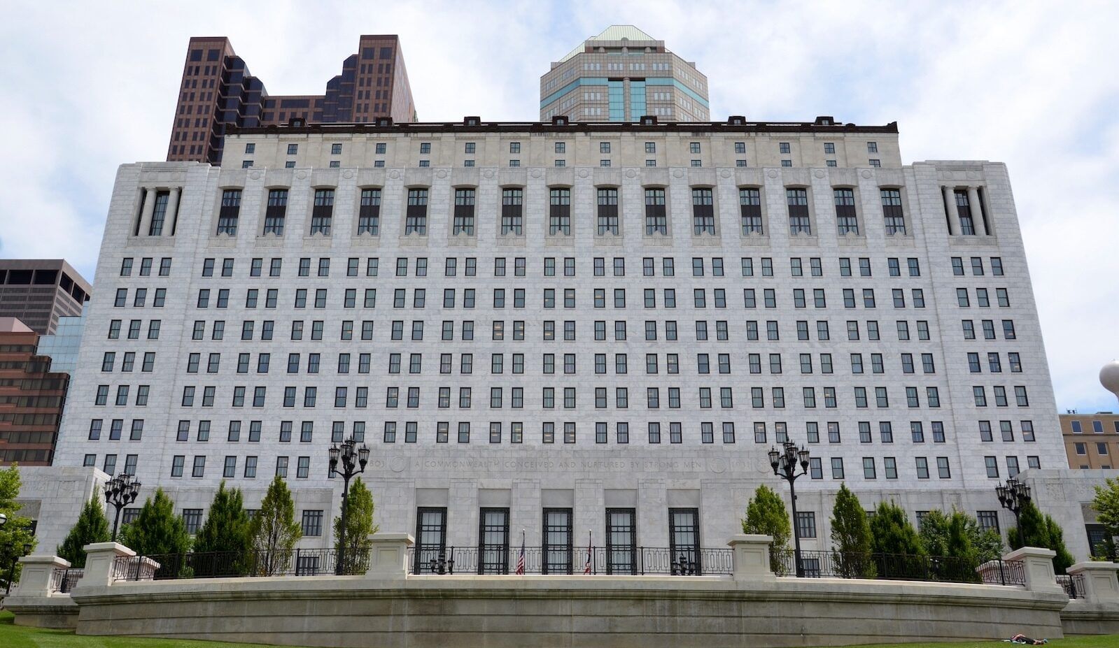 Large white rectangular building, with upper floors set back