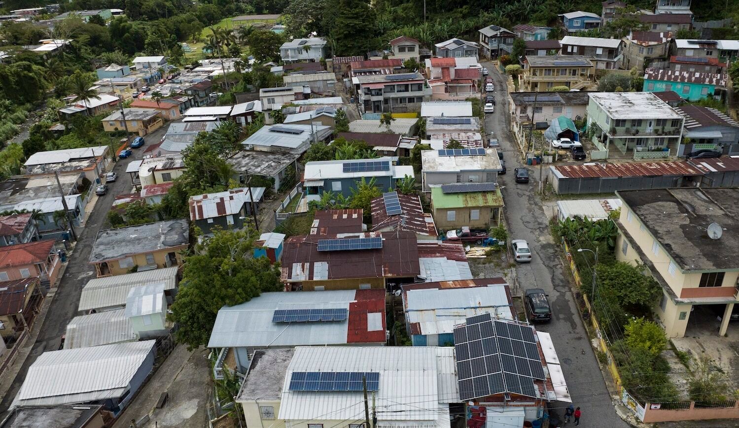 Many houses, one or two stories, with solar panel arrays of various sizes on the roof