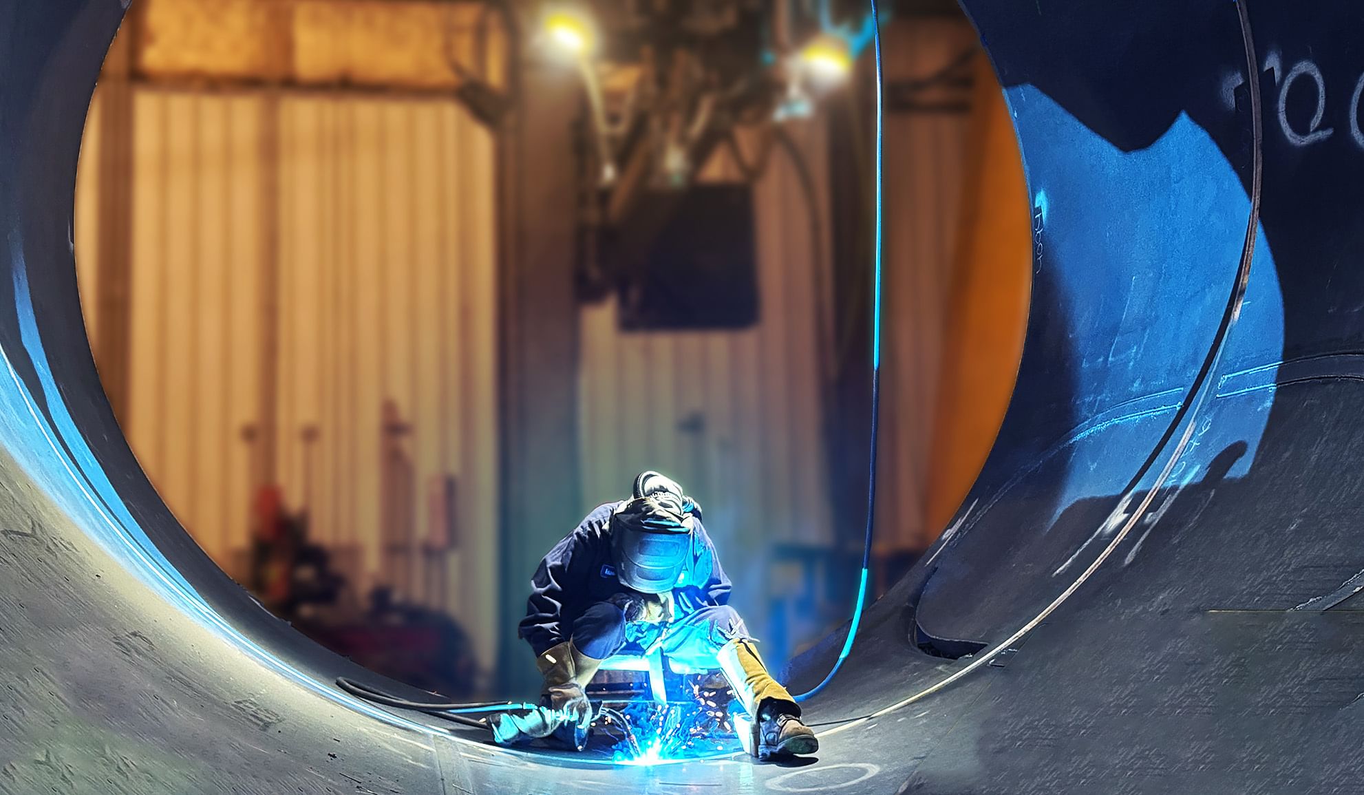 person welding in a big metal circle