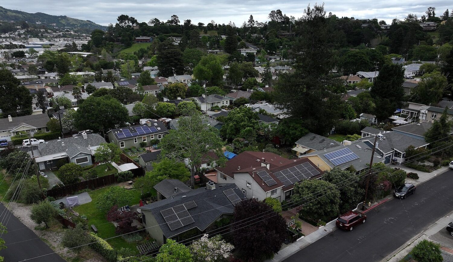 Homes with grassy lawns in a hilly neighborhood