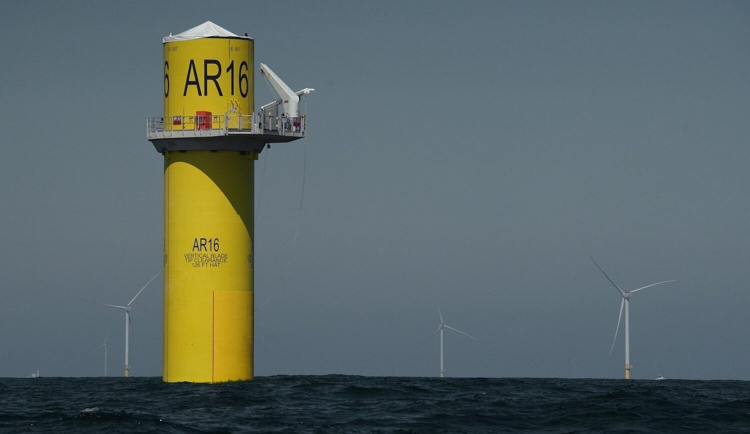Yellow turbine base surrounded by other complete turbines in awater