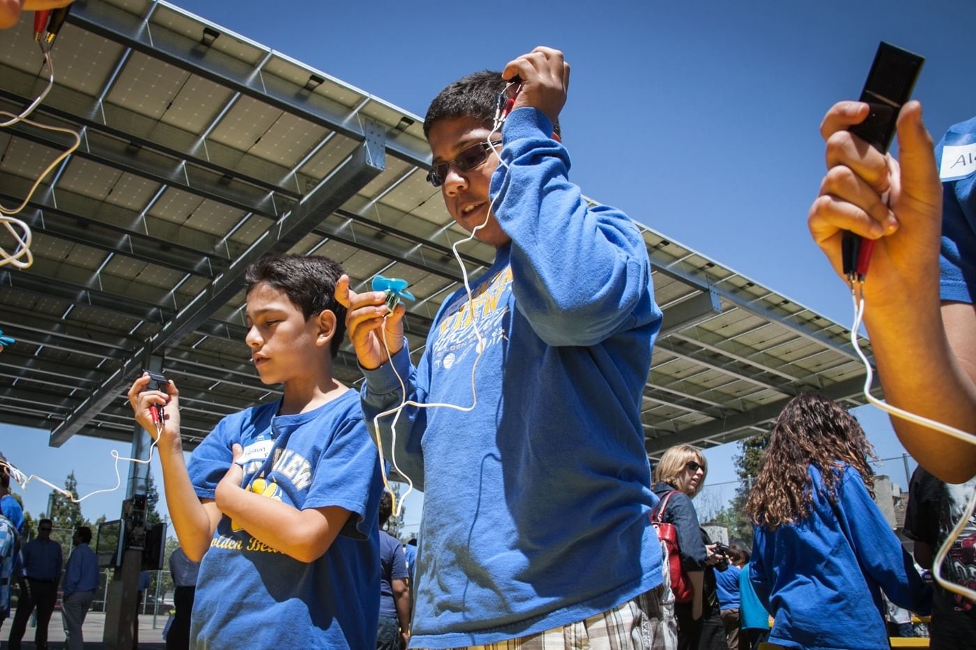 Students at a school in Merced, California use handheld solar sensors to check power output from a carport solar canopy