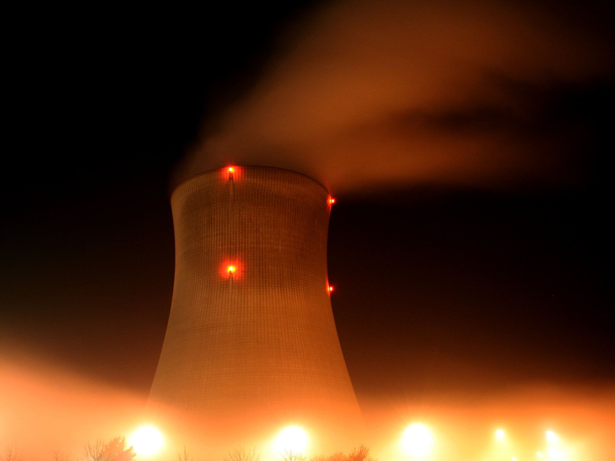 Nuclear cooling tower at night with glowing lights