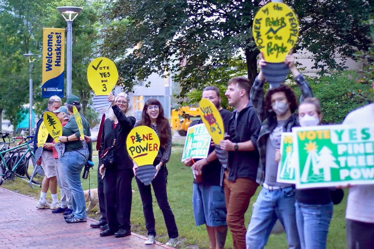 activists holding "Pine Tree Power" signs