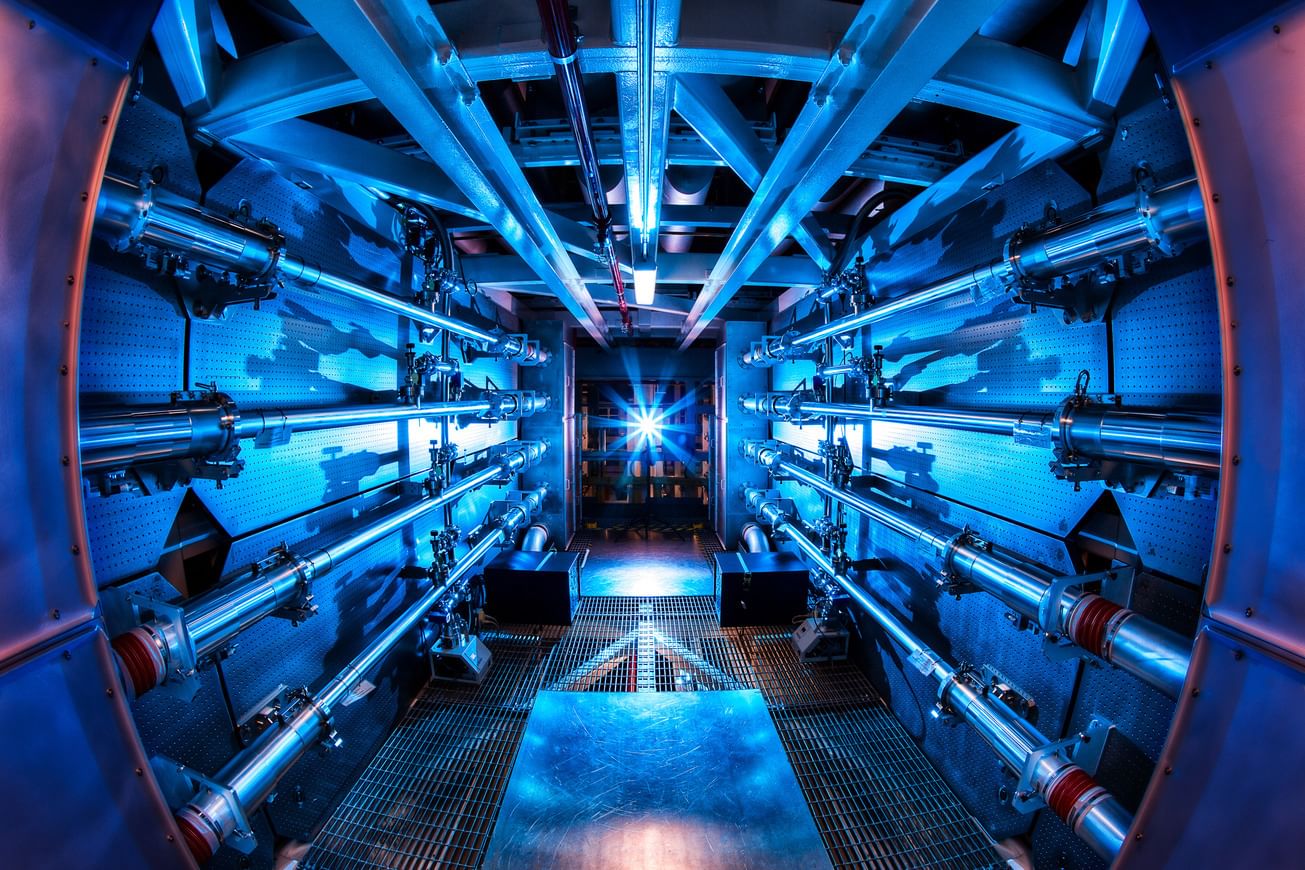 A long, narrow room with metallic tubes running the length of the walls, illuminated by blue light.
