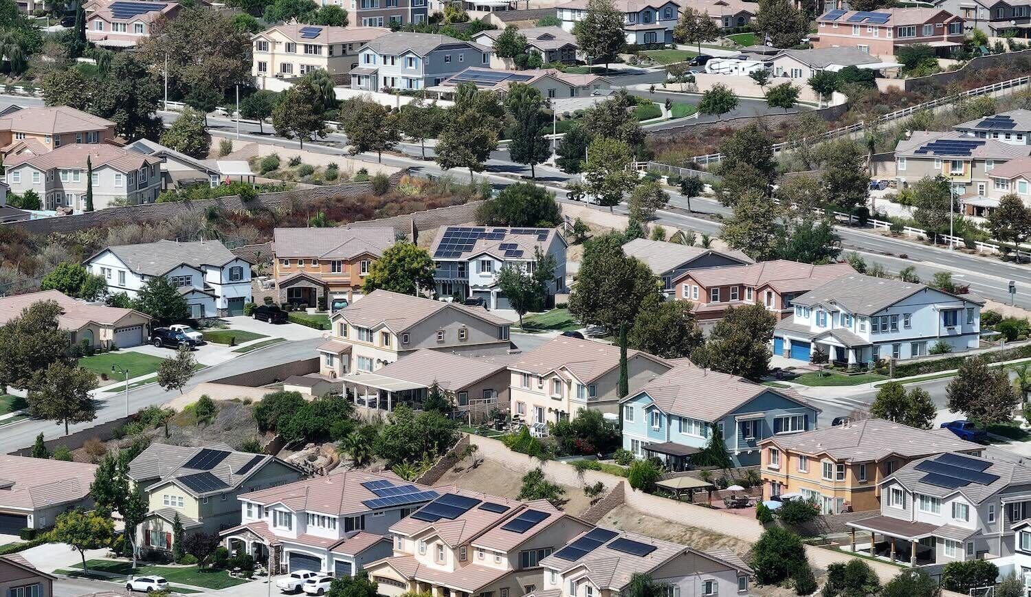 Aerial shot of homes, some with rooftop solar panels